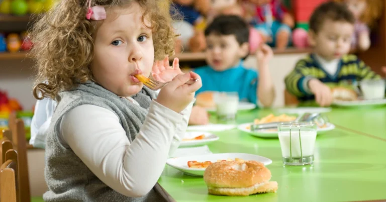 Little girl eating a healthy snack at her preschool. Healthy snacks for preschoolers that kids actually eat, including easy ideas for picky eaters plus simple tips for less stressful snack time.