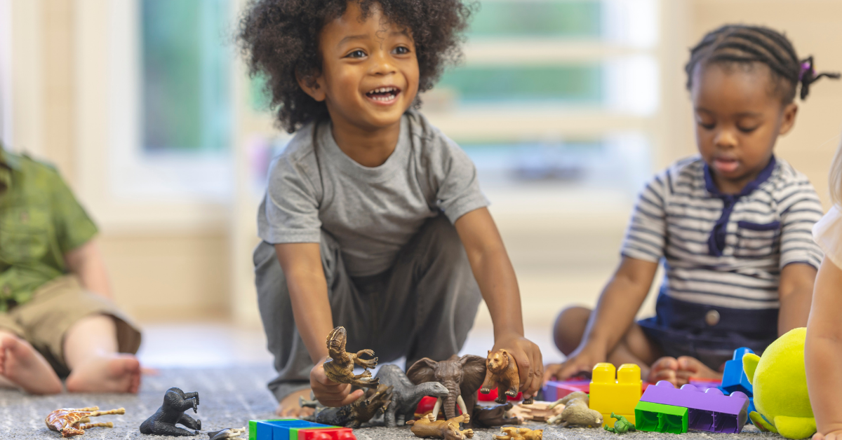 Preschoolers playing with dinosaurs and blocks